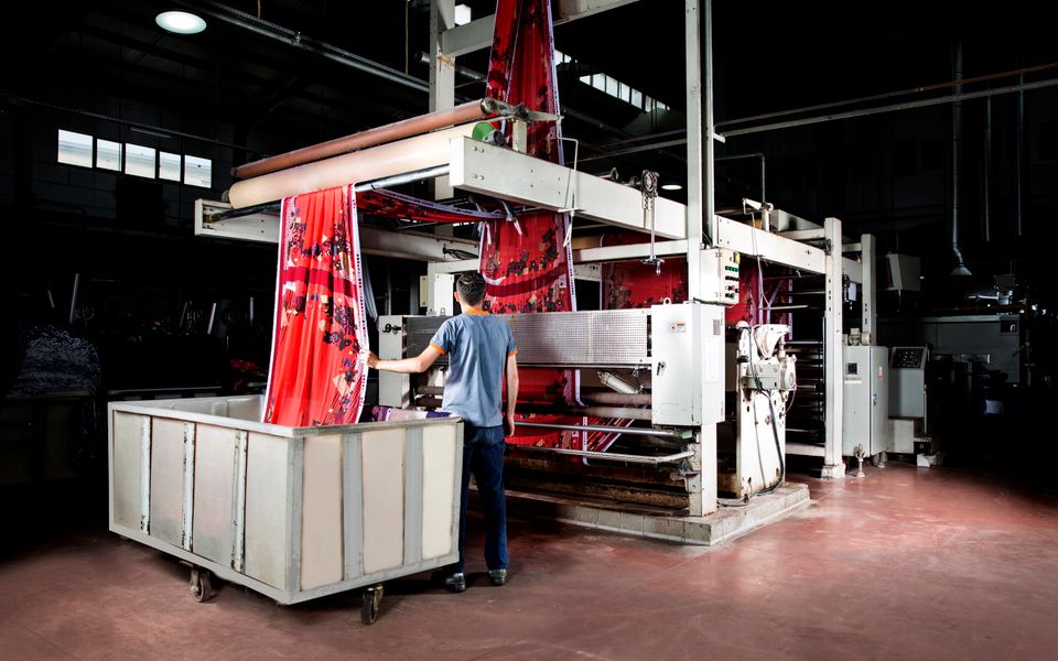Worker supervising machinery in a textile factory