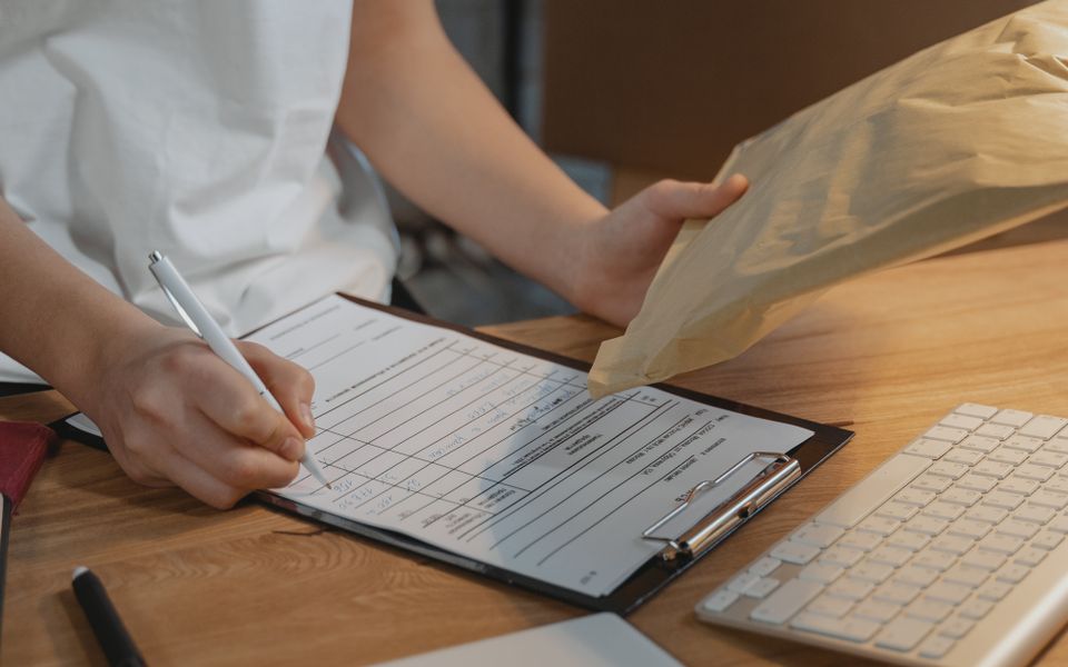 Person recording an order beside a received parcel